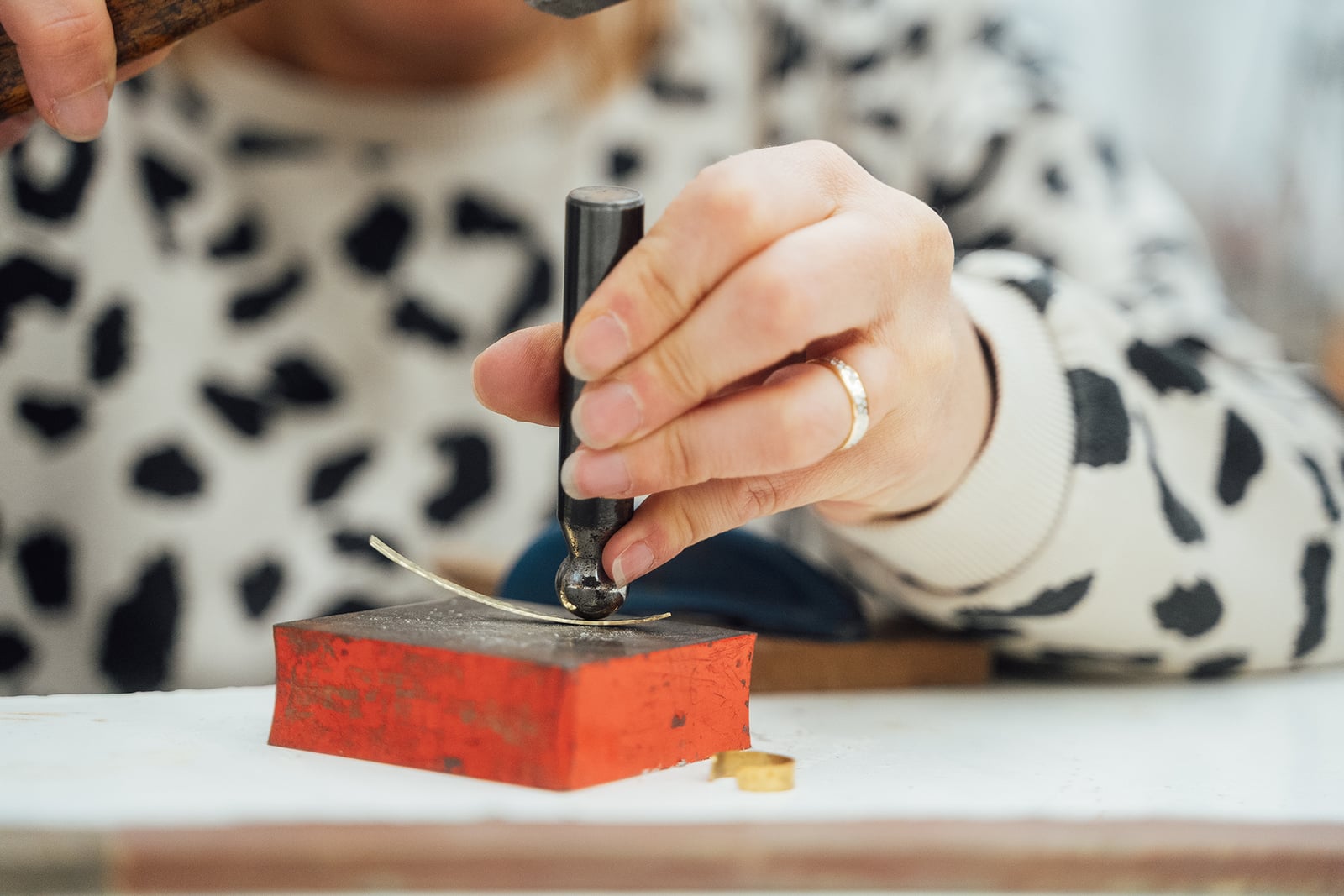 Martelage d'un bracelet pendant un atelier de bijouterie